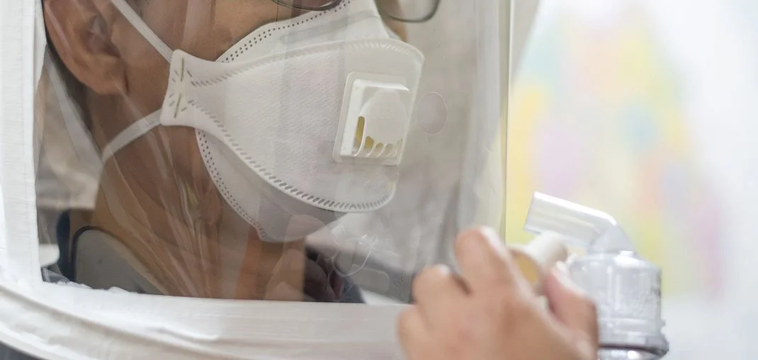 Worker undergoing qualitative respirator fit test with a hood and saccharin sensitivity check